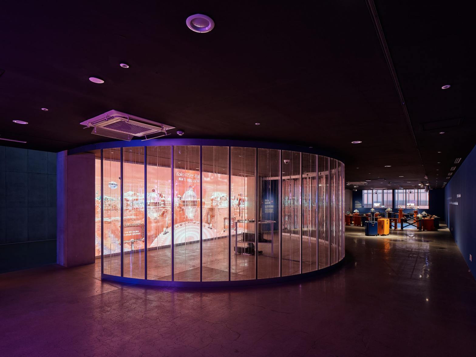 Installation view of Koko Killing Island: Tour d’Epicure by Inhwa Yeom, with a glowing circular VR environment and sculptural dining stations at MMCA Seoul